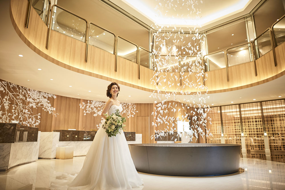 木の温もりが伝わり、吹き抜けから明るい光が降り注ぐ開放的なロビー